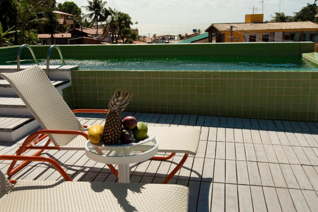 a bowl of fruit sitting on a table on a patio at Solar das Artes Pousada Boutique - Morro in Morro de São Paulo