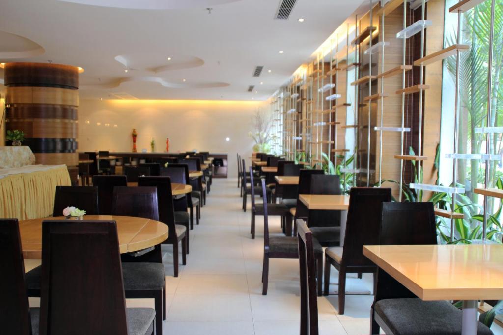 a dining room filled with tables and chairs at Poly Hotel, Guangzhou in Guangzhou