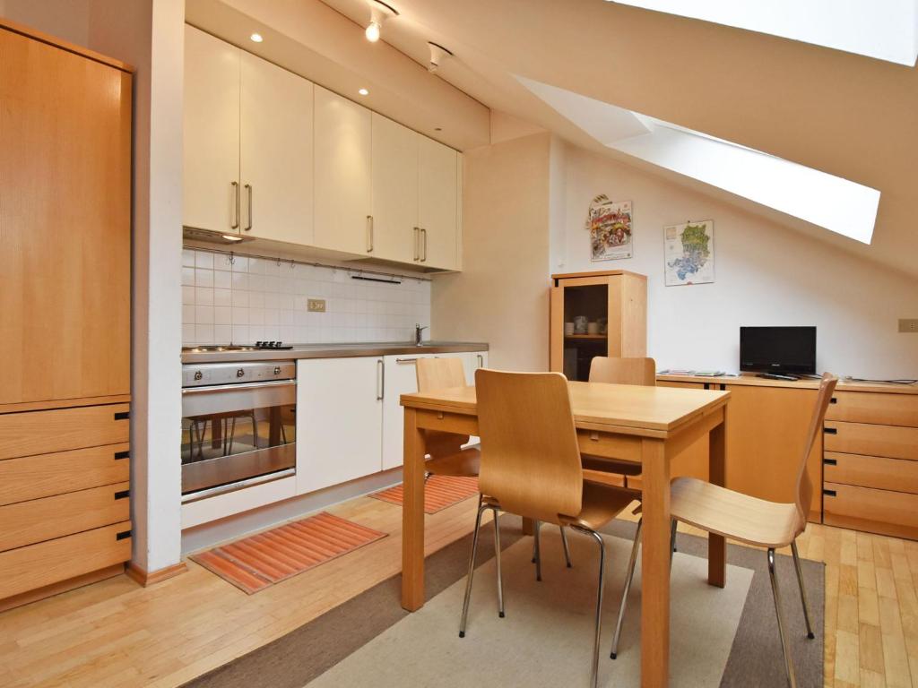 an open kitchen with a wooden table and chairs at Apartment Enrosadira-4 by Interhome in Alba di Canazei
