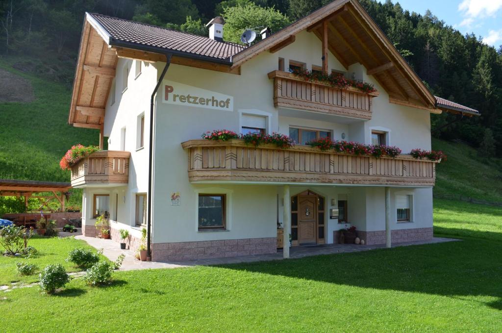 a house with a balcony on a green lawn at Pretzerhof in Campo di Trens
