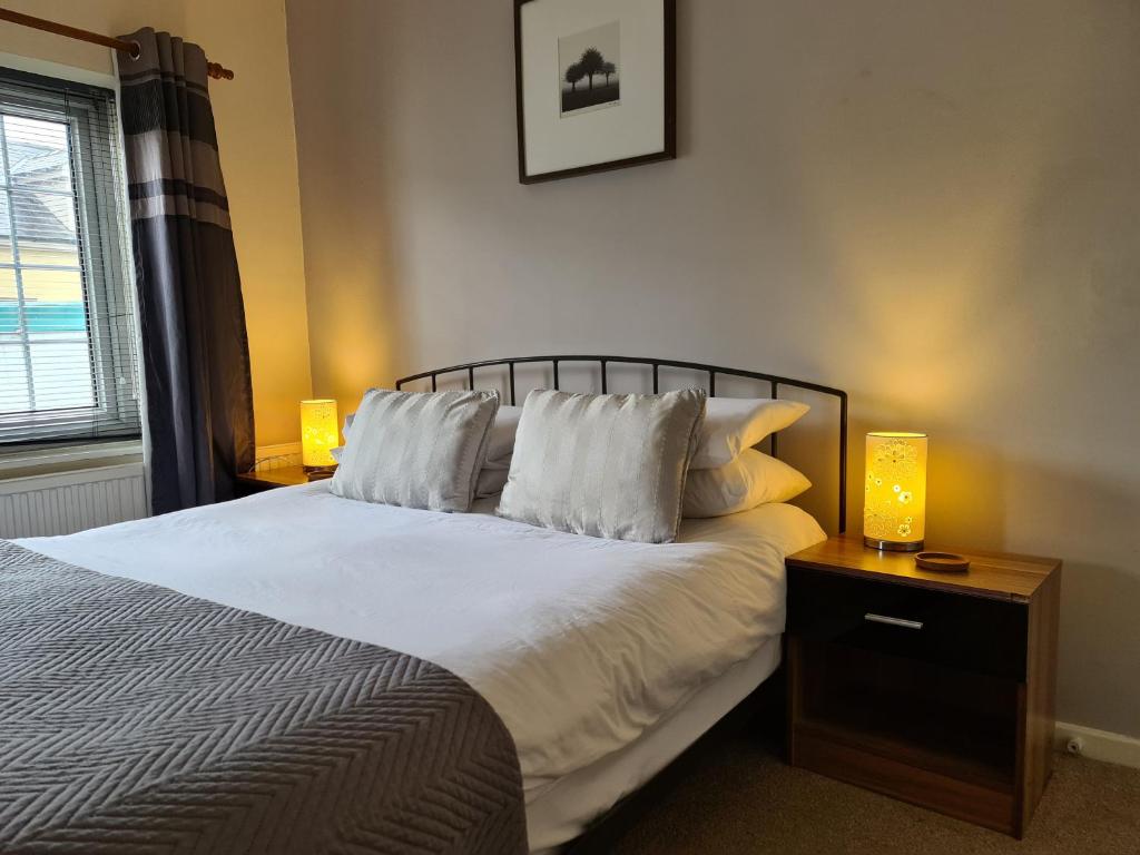 a bedroom with a bed with two lamps on a night stand at The Lamb and Flag Inn in Rhayader