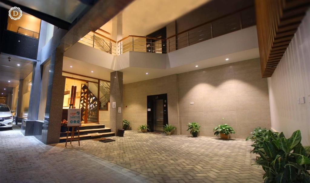 a lobby of a building with potted plants at Hotel Daani Continental in Imphal