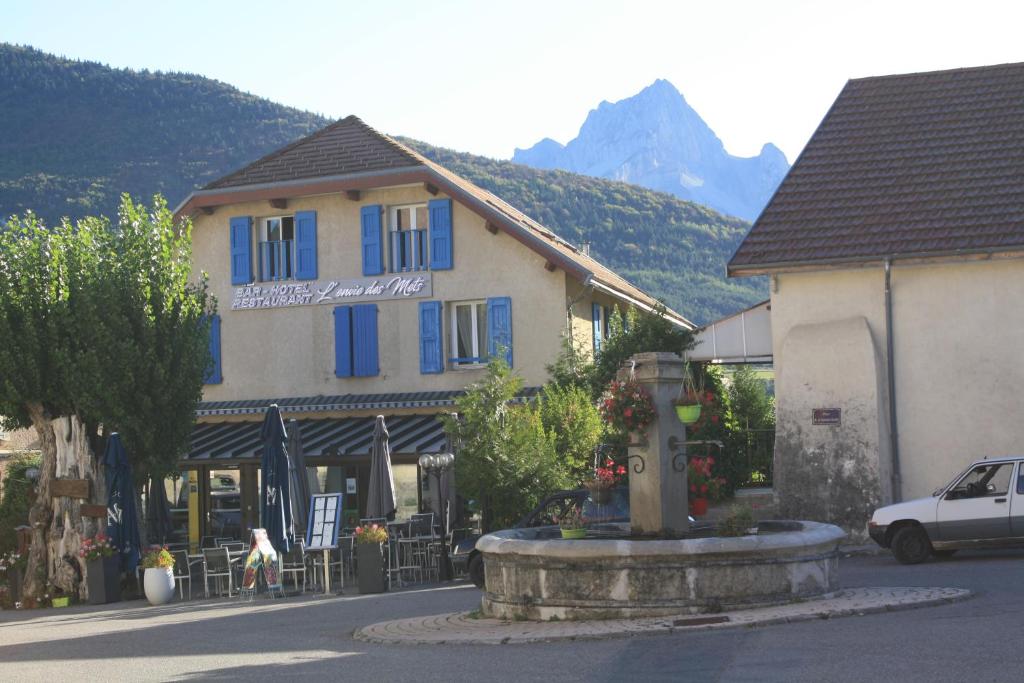 a building with a fountain in front of it at Hotel L'envie des mets in Lus-la-Croix-Haute