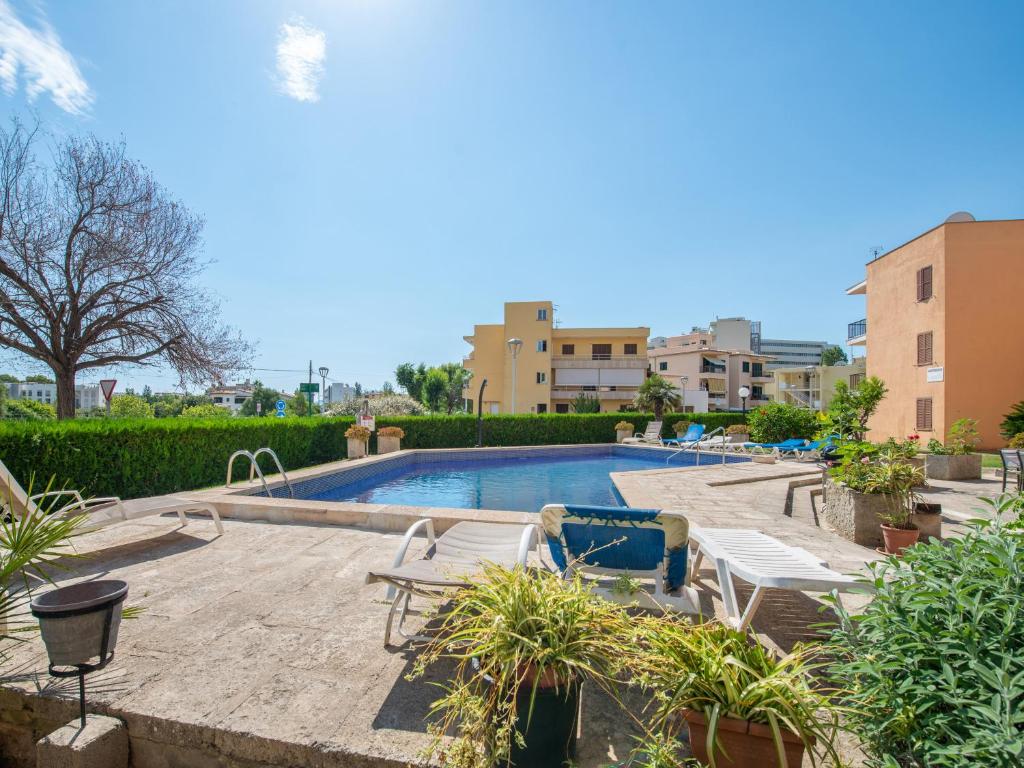 una piscina con 2 tumbonas y un complejo en Tamarels beach apartment in Pollensa en Pollença