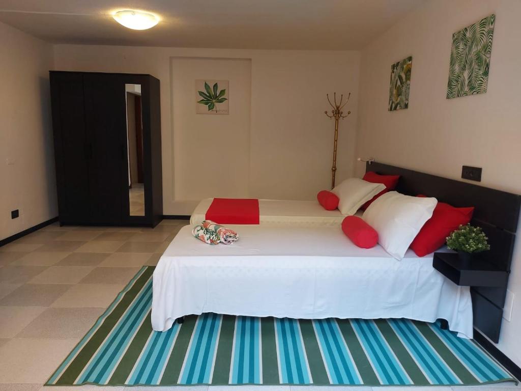 a bedroom with a large white bed with red pillows at Bnbook-Villa Molinari in Milan