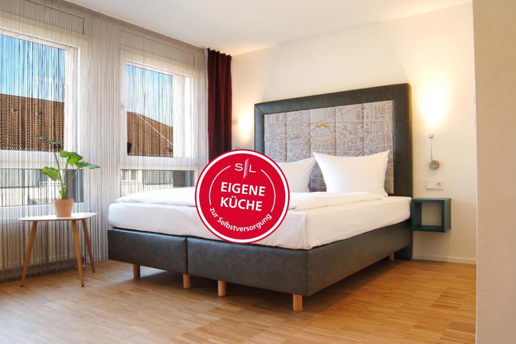a hotel room with a bed with a sign on it at SEEGER Living Premium Downtown in Karlsruhe
