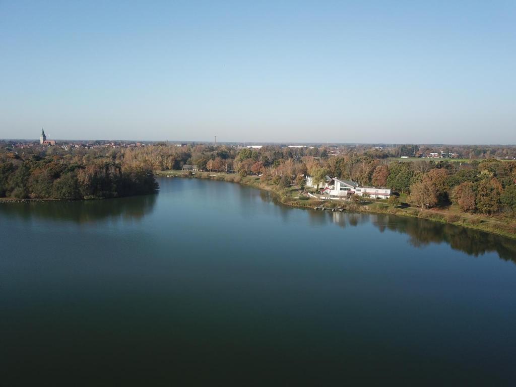 an aerial view of a large lake with trees at Haus am See Haselünne in Haselünne
