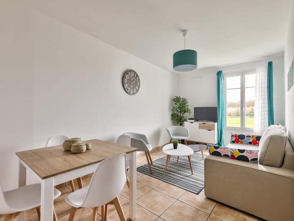 a white living room with a table and chairs at 123home-Le park side in Chessy