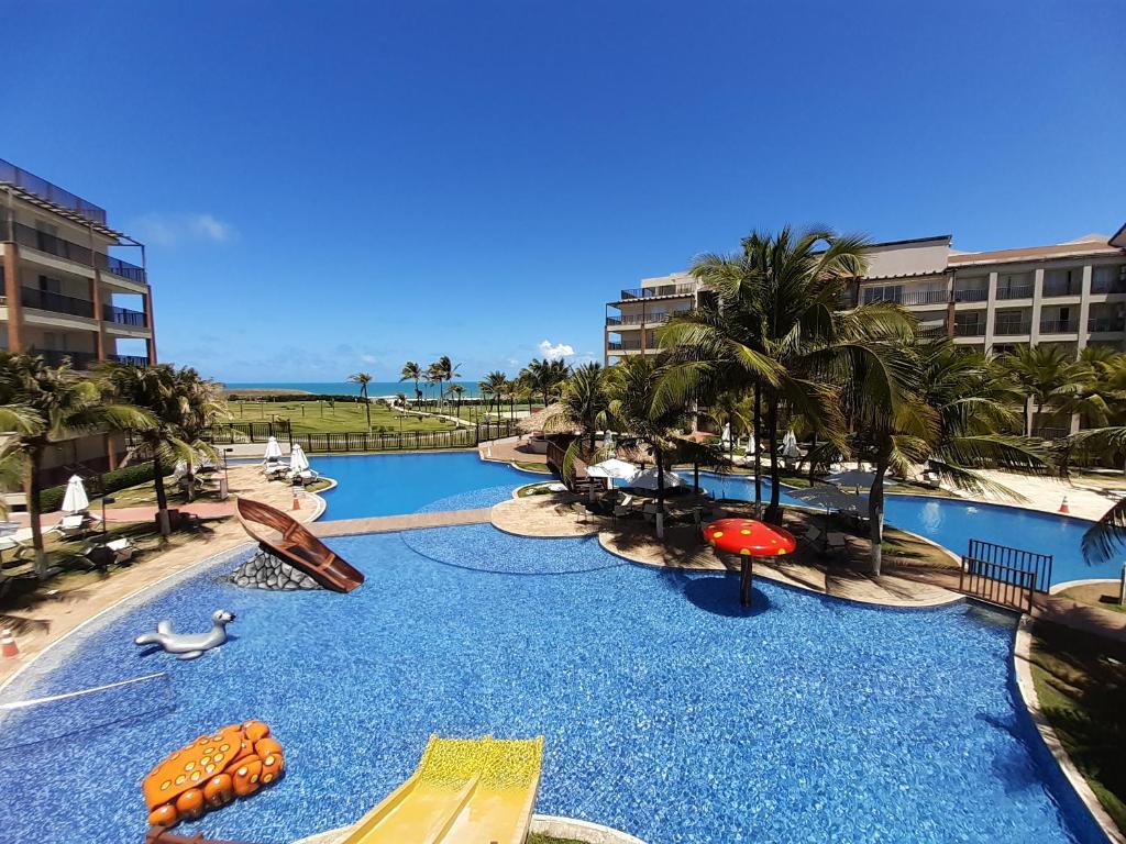 a resort with a pool with slides and a water park at Beach Living - Porto das Dunas - Ap Terreo 200m Beach Park PÉ NA AREIA in Aquiraz