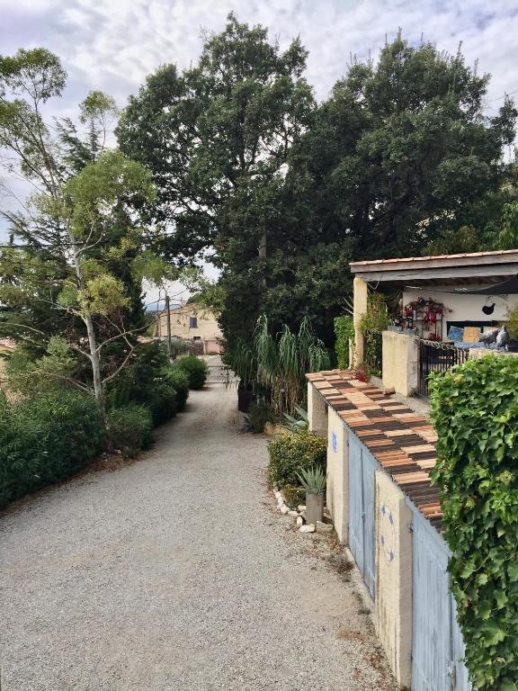 un chemin menant à une maison avec une clôture dans l'établissement Gites Mas Du Cadranier, à Villeneuve