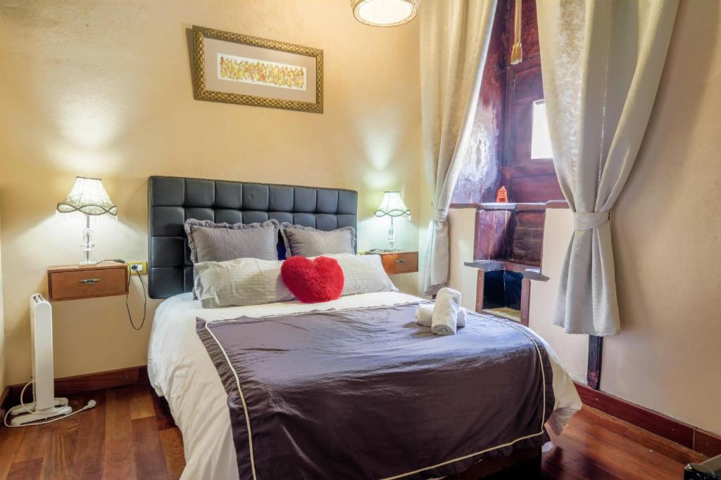 a bedroom with a large bed with a red pillow on it at Casa Tradicional Canaria in Garachico