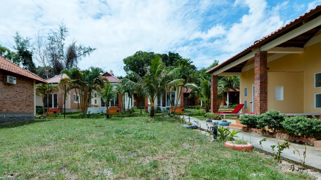 a yard of a house with palm trees at Vung Bau Resort in Phú Quốc