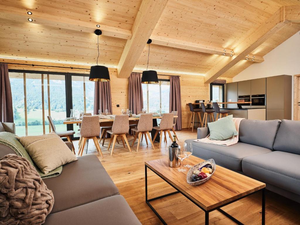 ein Wohnzimmer mit einem Sofa und einem Tisch in der Unterkunft Bergresort Hauser Kaibling by ALPS RESORTS in Haus im Ennstal