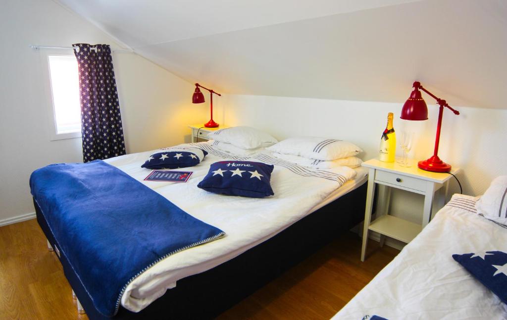 a bedroom with two beds with blue pillows on them at Smögens Gästhem in Smögen