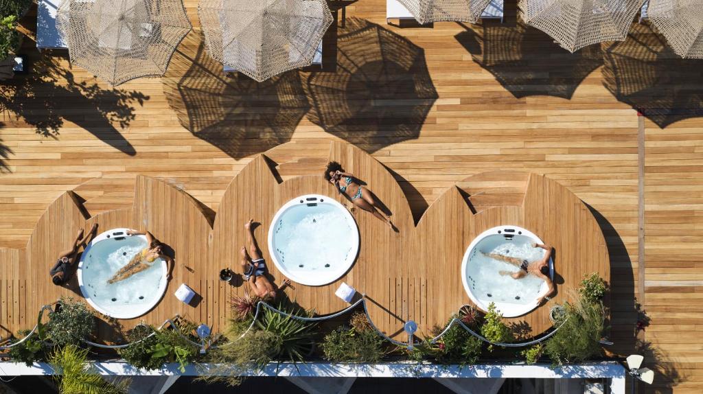 a wooden fence with three mirrors in the shape of the word om at Brown Acropol, a member of Brown Hotels in Athens