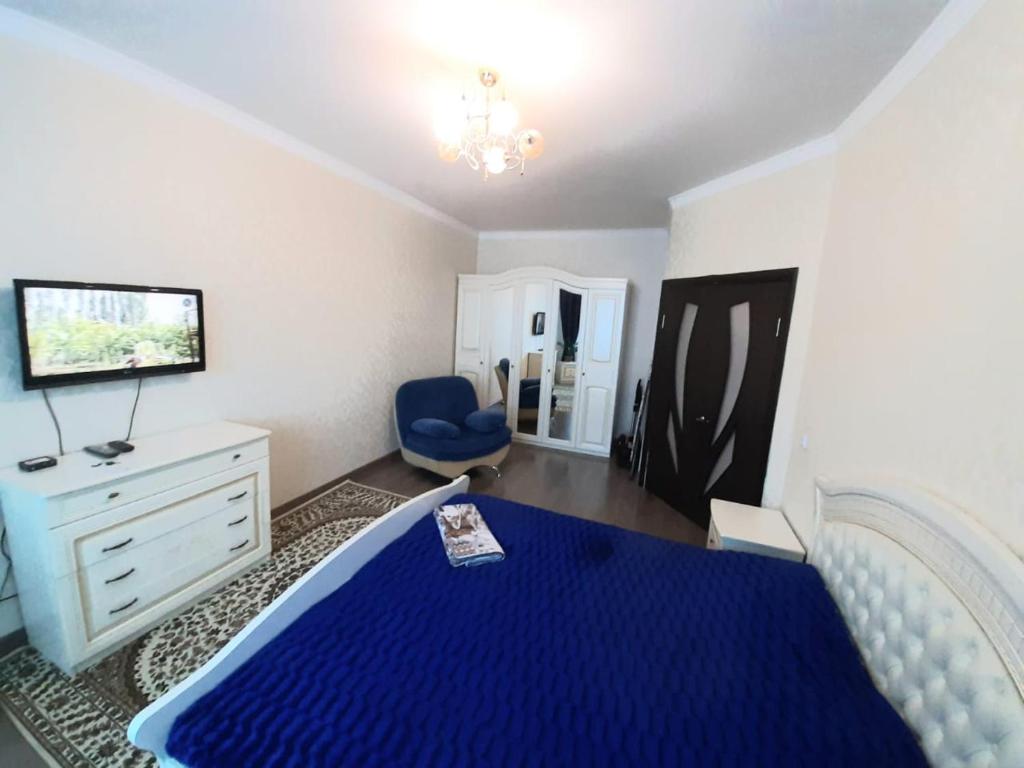 a bedroom with a blue bed and a blue chair at Однокомнатная квартира: ЖК Сенатор in Astana