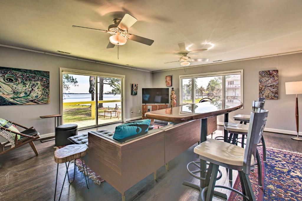 uma sala de estar com um bar e algumas cadeiras em Riverfront New Bern House Gourmet Kitchen and View! em New Bern