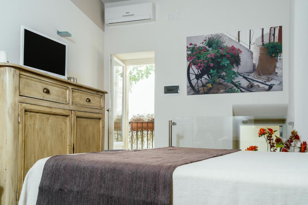 a bedroom with a large bed with a tv on the wall at Il Claustro - Bed and breakfast in Altamura