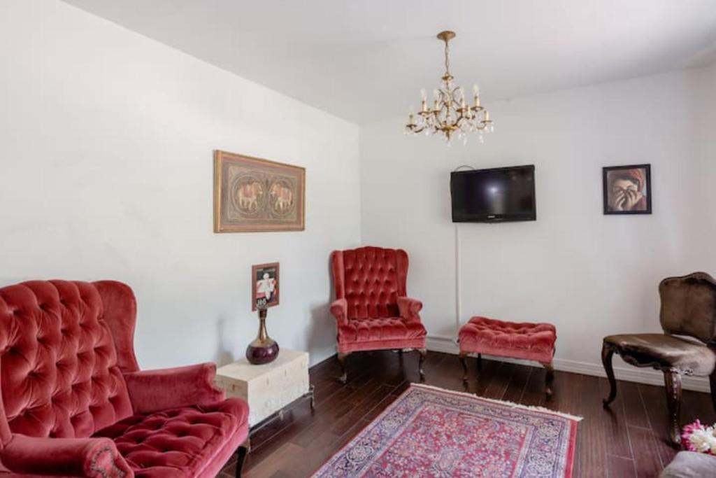 sala de estar con 2 sillas rojas y TV en Oasis 3 near DFW airport with Mediterranean setting, en Irving
