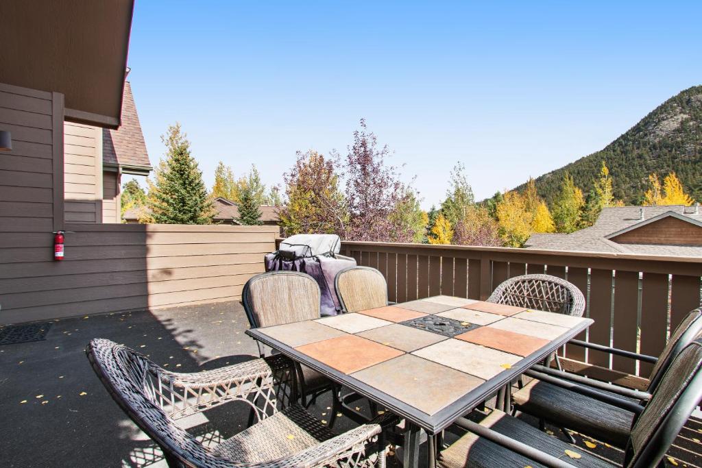 a patio with a table and chairs on a deck at Retreat By The Rockies #3149 in Estes Park