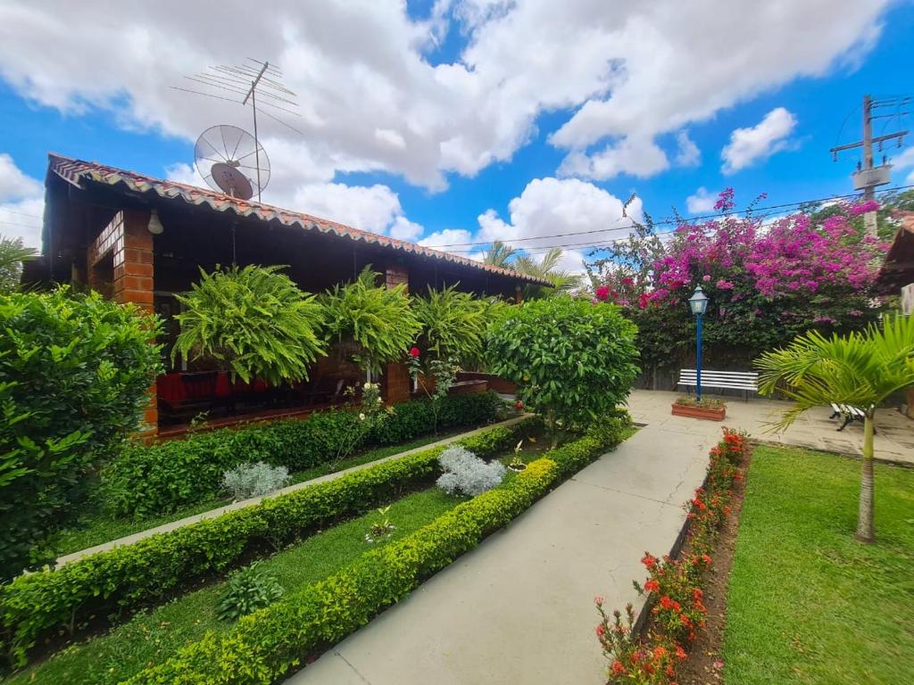 a garden in front of a building with flowers at Chalé aconchegante na Serra Pernambucana - Em condomínio - Gravatá in Gravatá