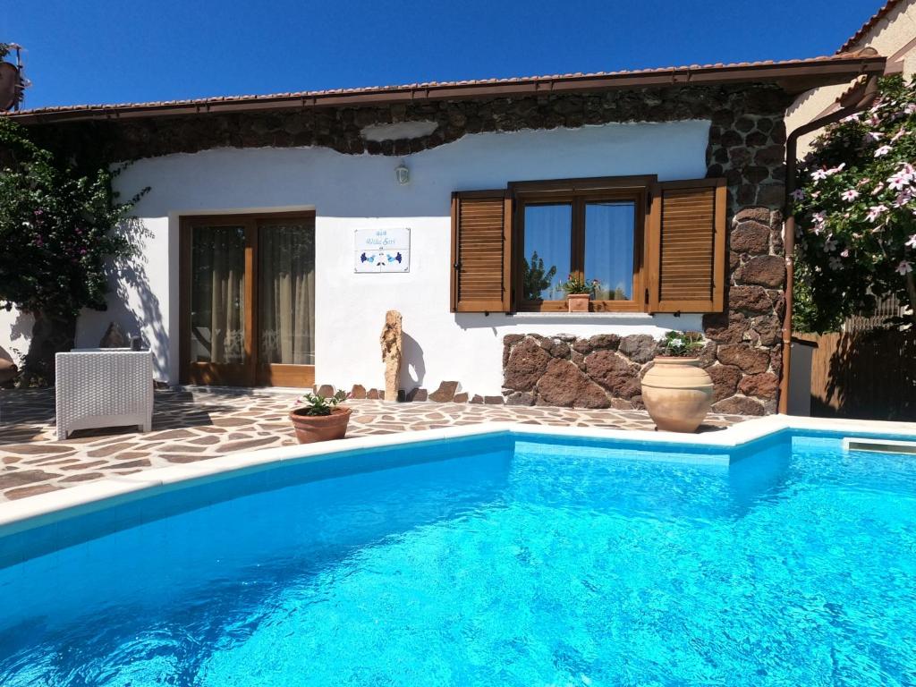 een villa met een zwembad voor een huis bij Villa Sari affitta camere in La Caletta