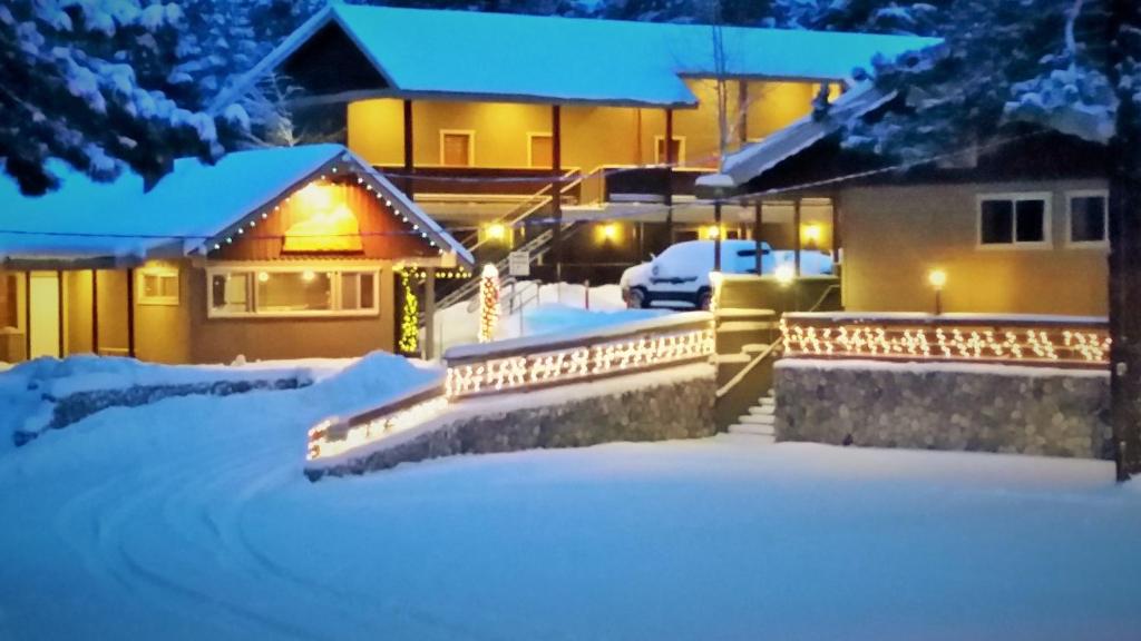 een huis bedekt met sneeuw 's nachts met lichten bij Holiday Haus in Mammoth Lakes