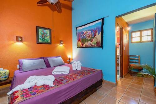sypialnia z fioletowym łóżkiem w pokoju w obiekcie The Grateful Hotel w mieście Playa Grande