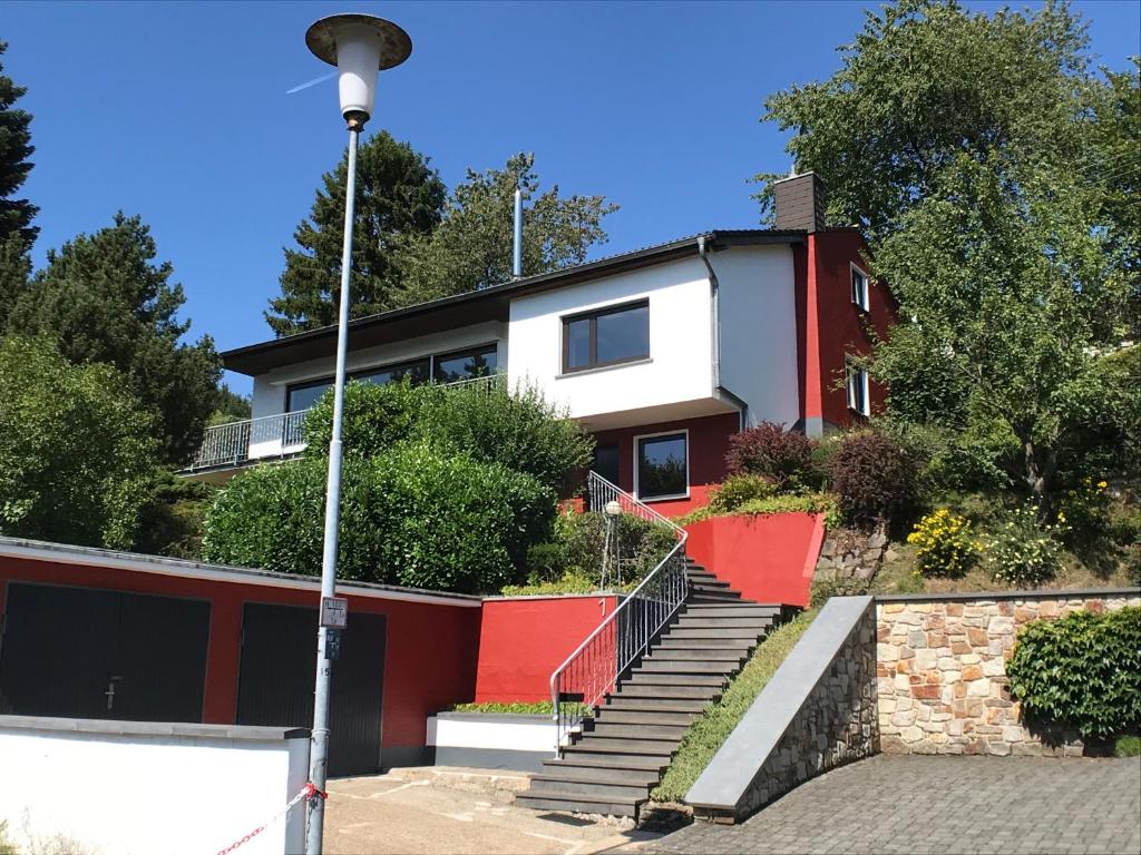 a red and white house with stairs and trees at Villa Im Bongert - Tor zum Nationalpark Eifel in Hellenthal