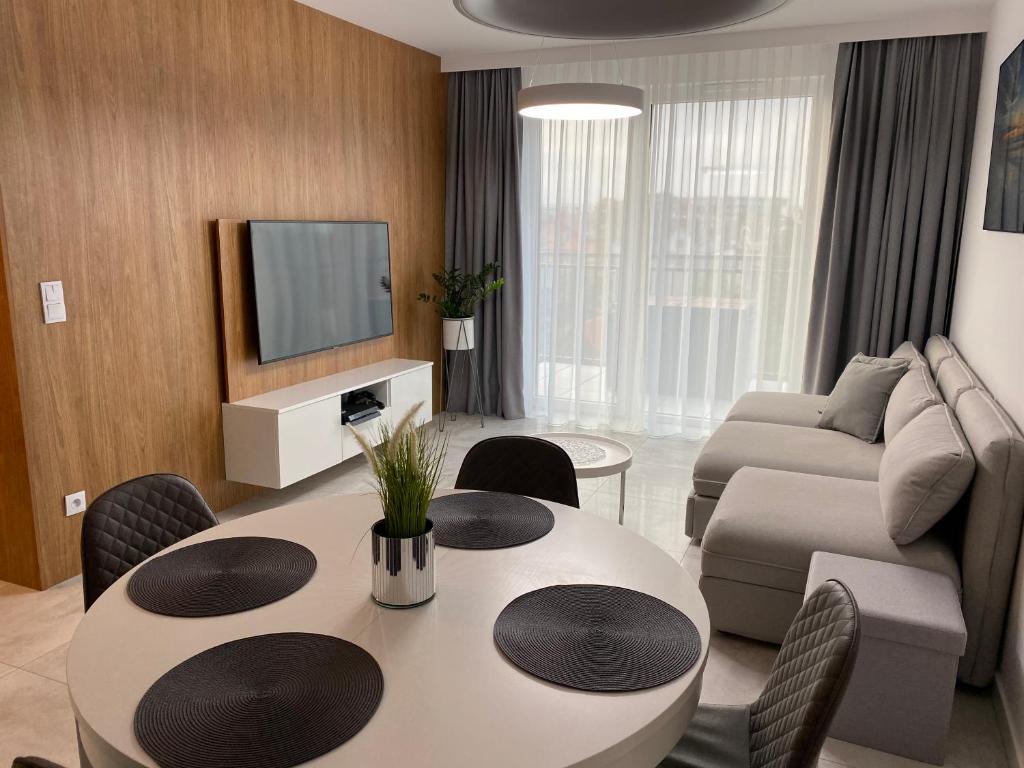 ein Wohnzimmer mit einem Tisch und einem Sofa in der Unterkunft Bel Mare Comfort 305 Apartament in Misdroy