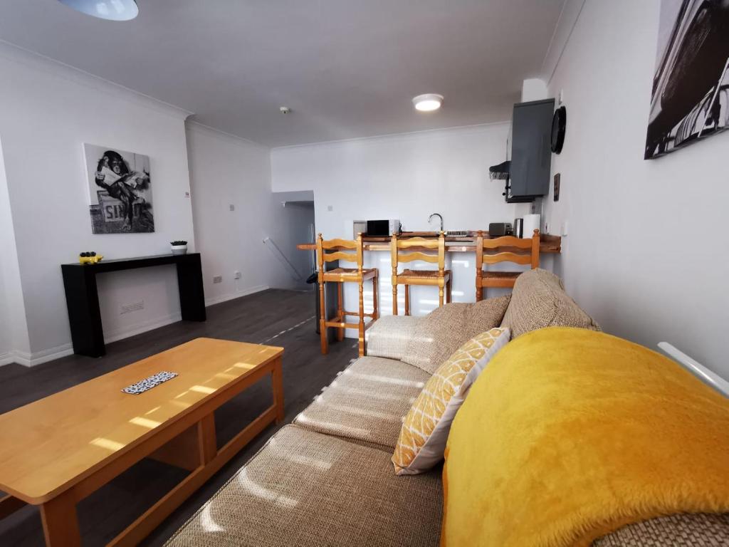 a living room with a couch and a table at High Street Flats in Broadstairs