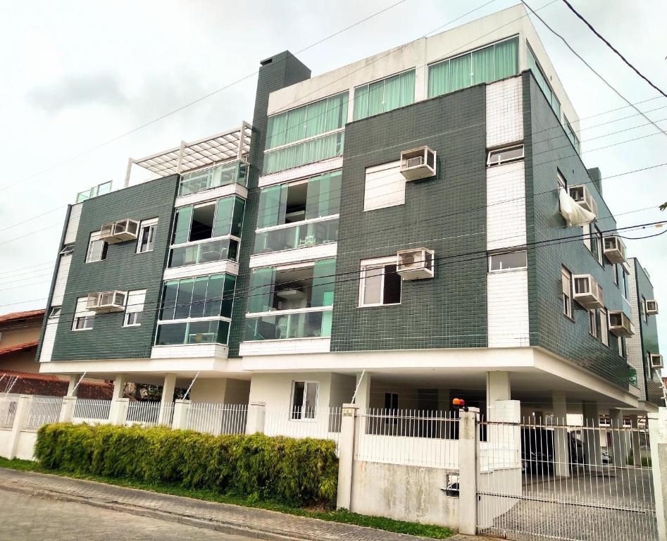 un edificio con zonas verdes y blancas en Apartamento de 2 quartos a 3 minutos a pé da praia de Cachoeira de Bom Jesu com águas calmas, en Florianópolis