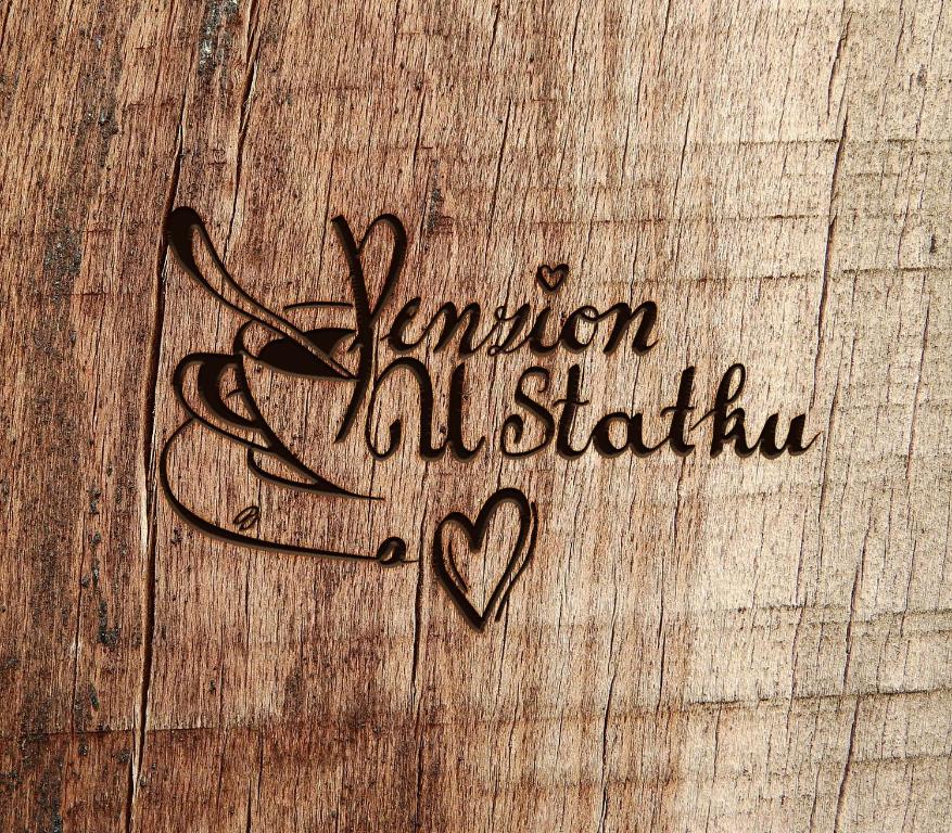 a sign on a wooden table with a heart at Penzion U Statku in Lodhéřov