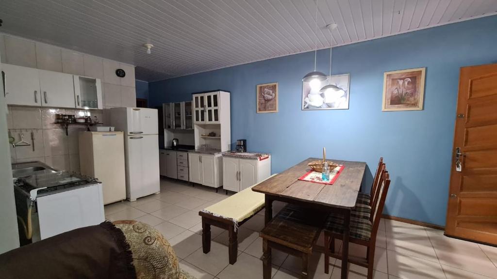 a kitchen with a table and a blue wall at MARÉ - Paz e Sossego in Tramandaí