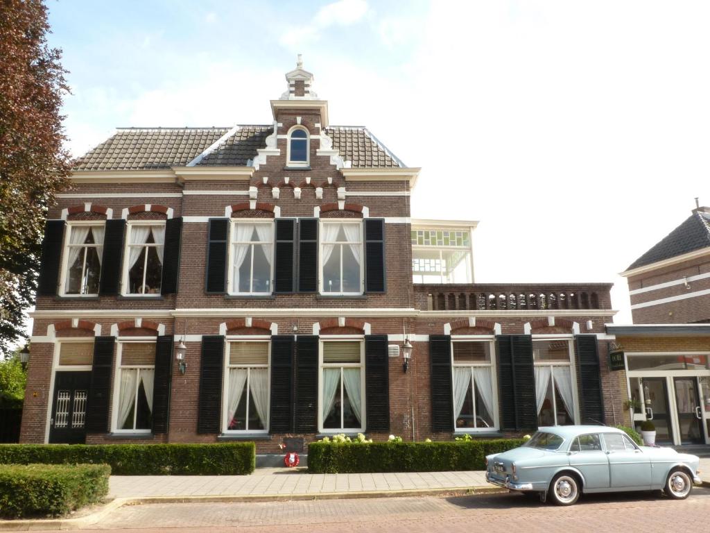 a car parked in front of a brick building at Hotel het Oude Postkantoor in Brummen