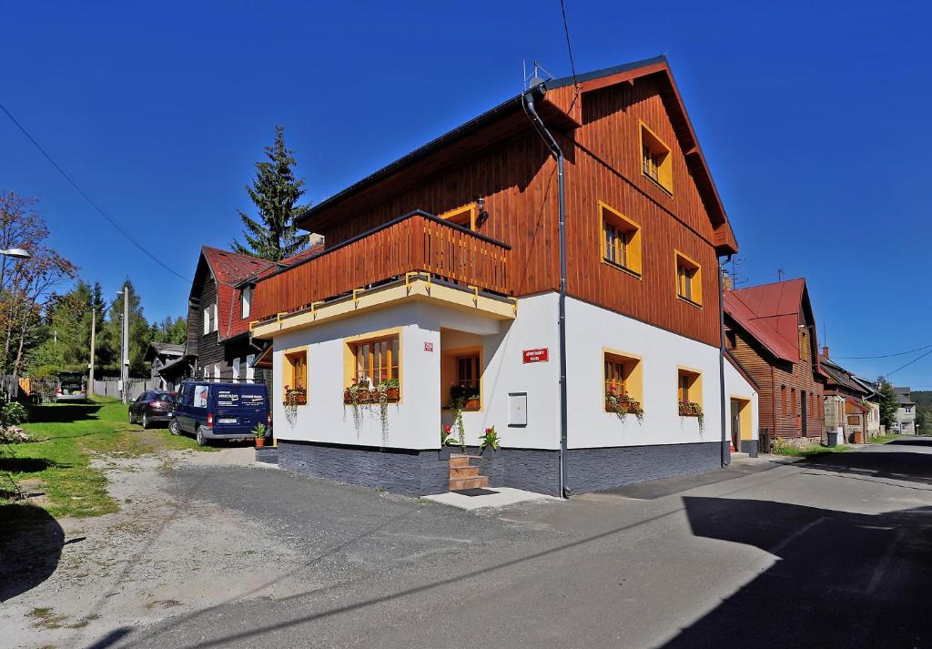 a large wooden building with windows on a street at Apartments Pavel in Abertamy