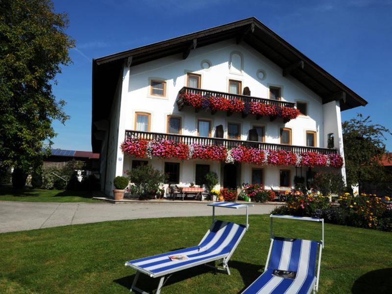 two chairs sitting in the grass in front of a building at Hofbauer in Seebruck