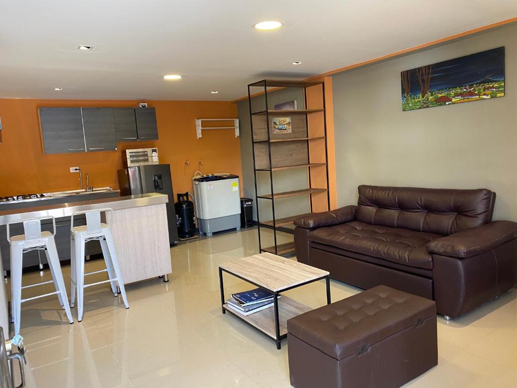 cocina y sala de estar con sofá y mesa en Apartamentos Maridiaz a 7 minutos de todo lo que necesitas !!!, en Pasto