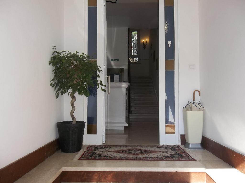 un corridoio con una pianta in vaso e un corridoio con un corridoio di Hotel Amalfi a Milano
