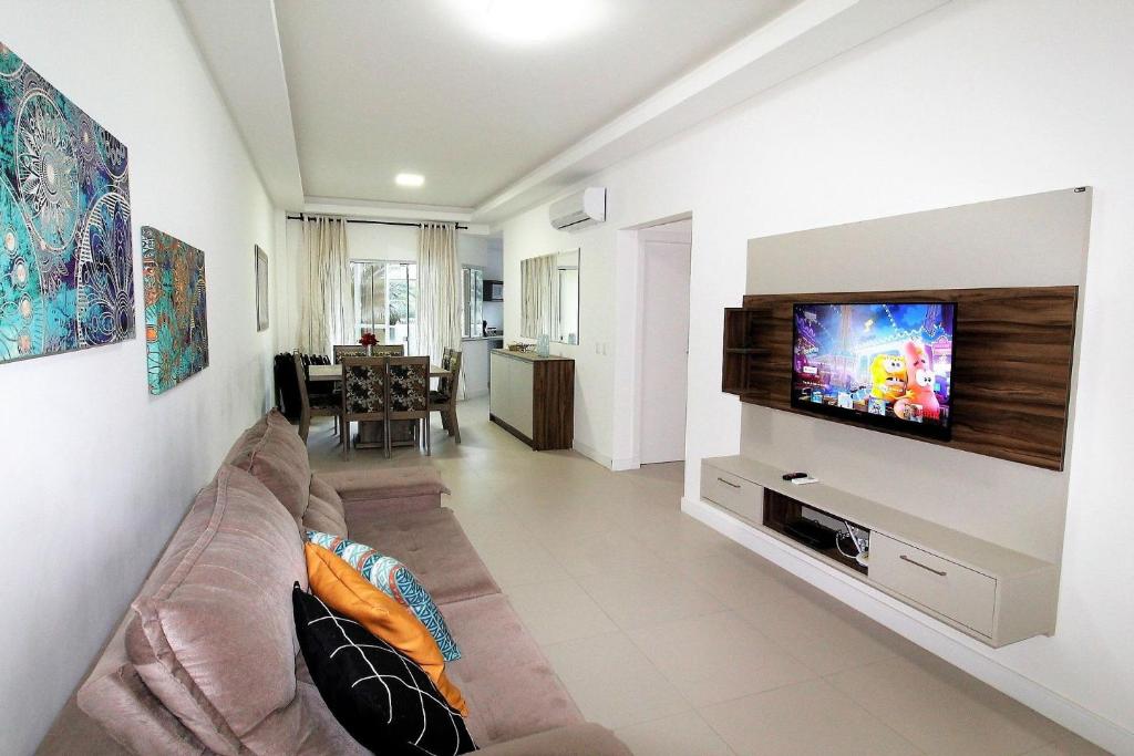 sala de estar con sofá y TV de pantalla plana en 1067 - Apartamento para locação em Bombinhas com 03 suítes, en Bombinhas