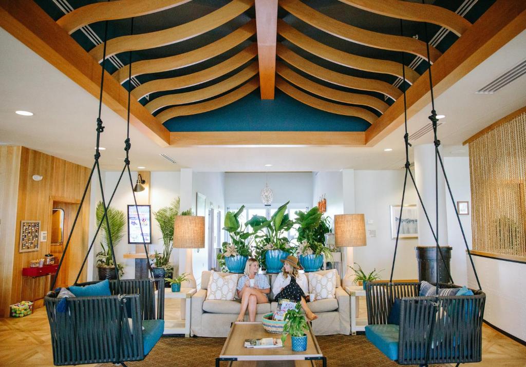 a living room with two girls sitting on a couch at Hotel Indigo Orange Beach - Gulf Shores by IHG in Gulf Shores