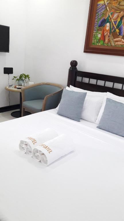 a white bed with two towels on top of it at SOFIATEL Rooms in Santa Maria