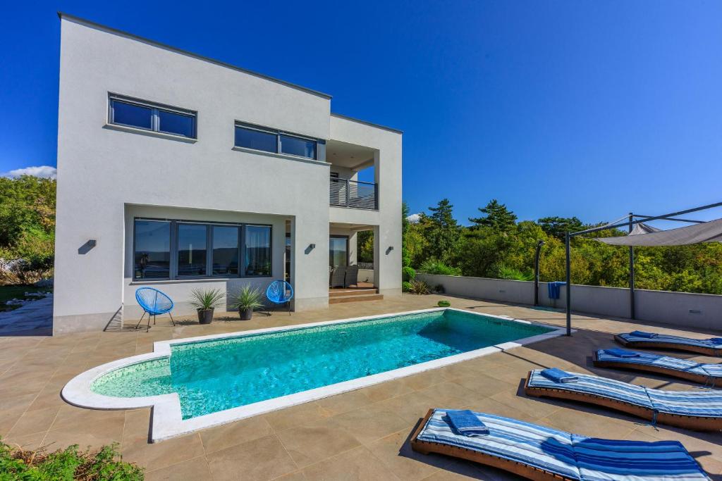 a villa with a swimming pool in front of a house at Villa Legara in Crikvenica