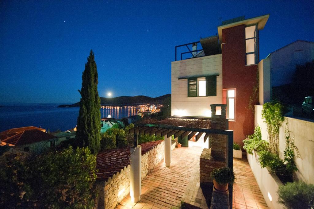 a house with a brick walkway in front of it at night at Villa Tangerine Vis in Vis