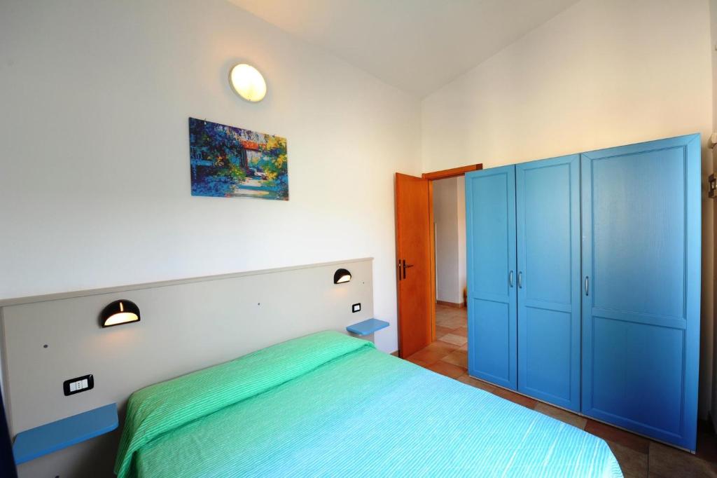 - une chambre avec un lit et une armoire bleue dans l'établissement Apartments in Peschiera del Garda 22099, à Peschiera del Garda