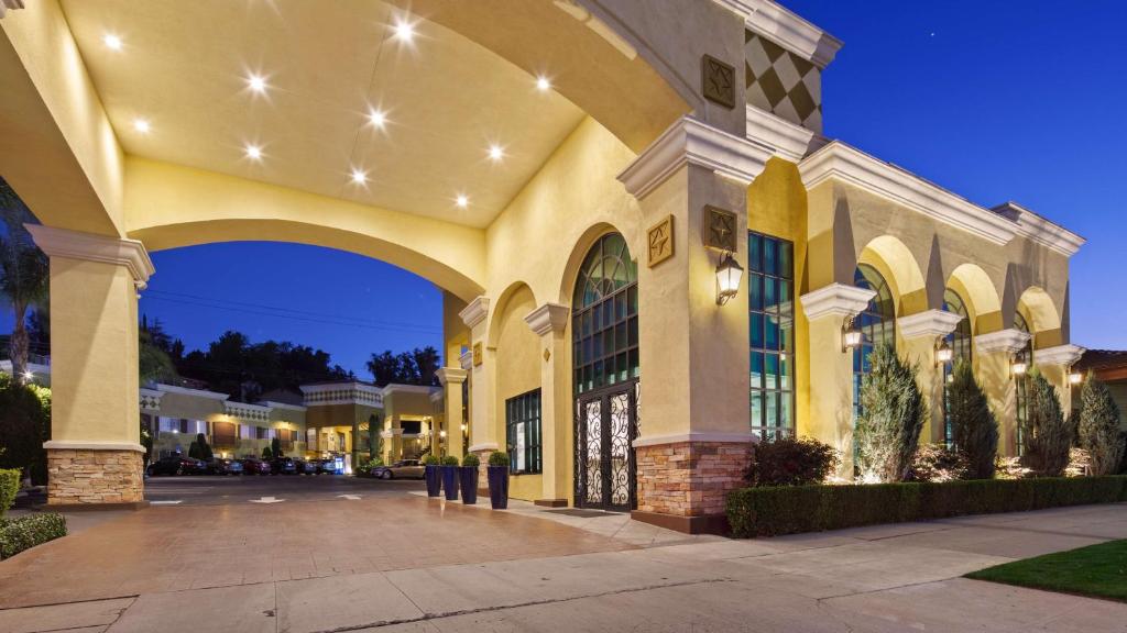 un grande edificio giallo con arco di notte di Best Western Woodland Hills a Woodland Hills