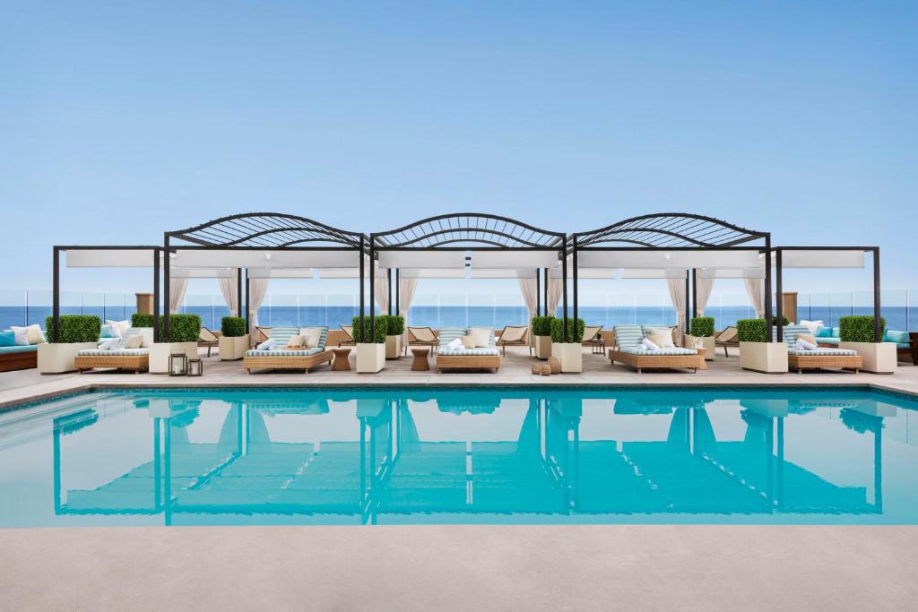 a swimming pool with couches and a pavilion at Surf and Sand Resort in Laguna Beach