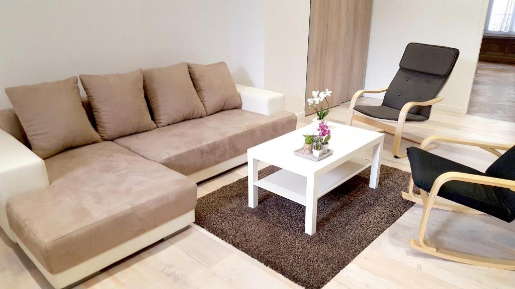 - un salon avec un canapé, une table et des chaises dans l'établissement L'Haussmannien Stéphanois, à Saint-Étienne