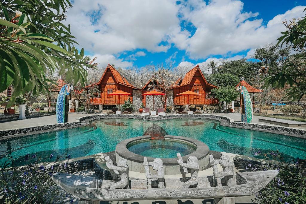 a swimming pool in front of a resort at Jukung Cottage in Nusa Penida