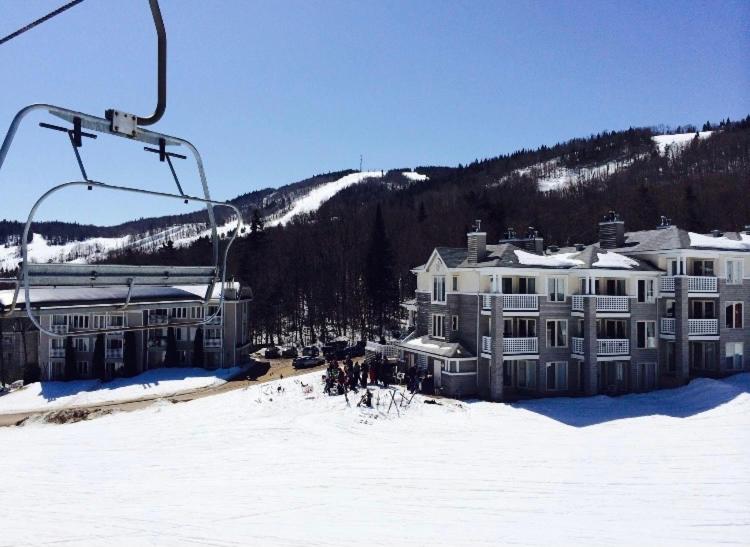 a large house in the snow with a ski lift at Condo loft ski in - ski out à Stoneham in Stoneham